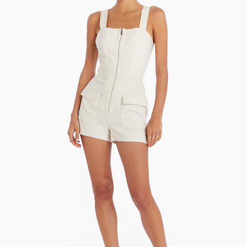 Girl in cream zip up romper, front facing.