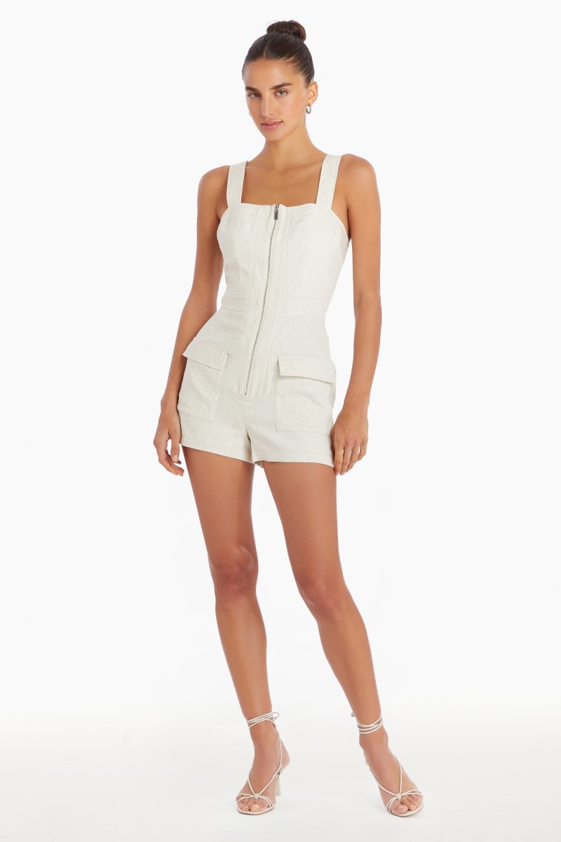 Girl in cream zip up romper, front facing.