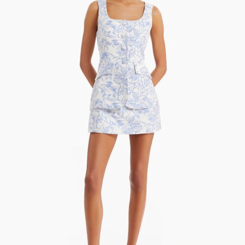 Girl in blue brocade romper dress, front facing.